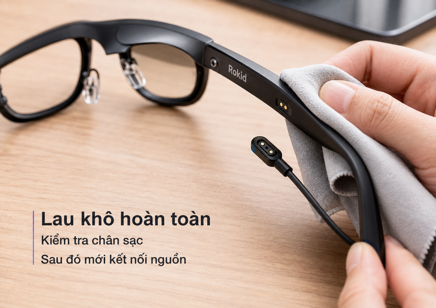 Người dùng kiểm tra và lau khô chân sạc Kính Thông Minh Rokid trước khi kết nối cáp sạc.